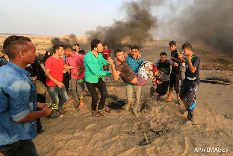 A wounded Palestinian protester is evacuated during clashes with Israeli troops in tents protest where Palestinians demand the right to return to their homeland at the Israel-Gaza border, in al-Bureij in the center of Ga...
