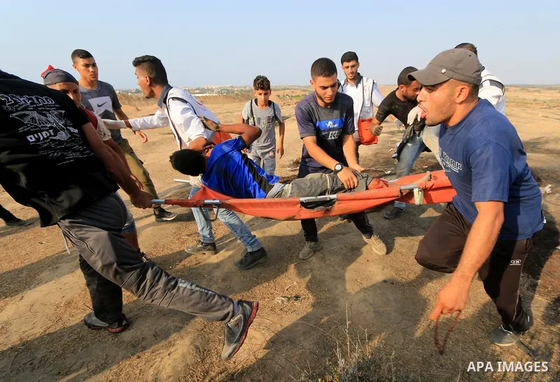 A wounded Palestinian protester is evacuated during clashes with Israeli troops in tents protest where Palestinians demand the right to return to their homeland at the Israel-Gaza border, in al-Bureij in the center of Ga...