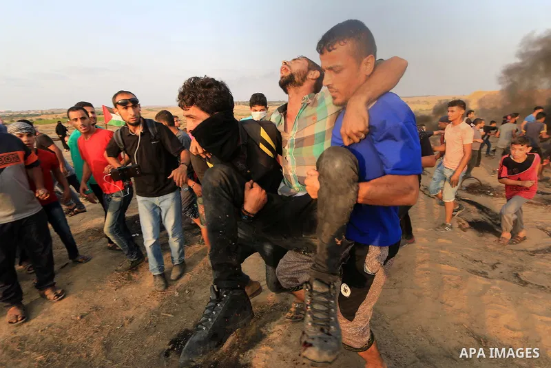 A wounded Palestinian protester is evacuated during clashes with Israeli troops in tents protest where Palestinians demand the right to return to their homeland at the Israel-Gaza border, in al-Bureij in the center of Ga...