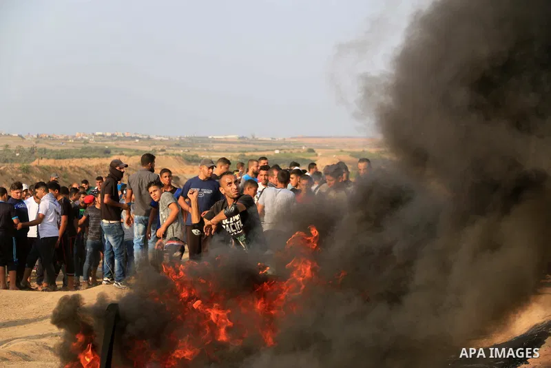 Palestinian protesters gather during clashes with Israeli troops in tents protest where Palestinians demand the right to return to their homeland at the Israel-Gaza border, in al-Bureij in the center of Gaza Strip on Aug...