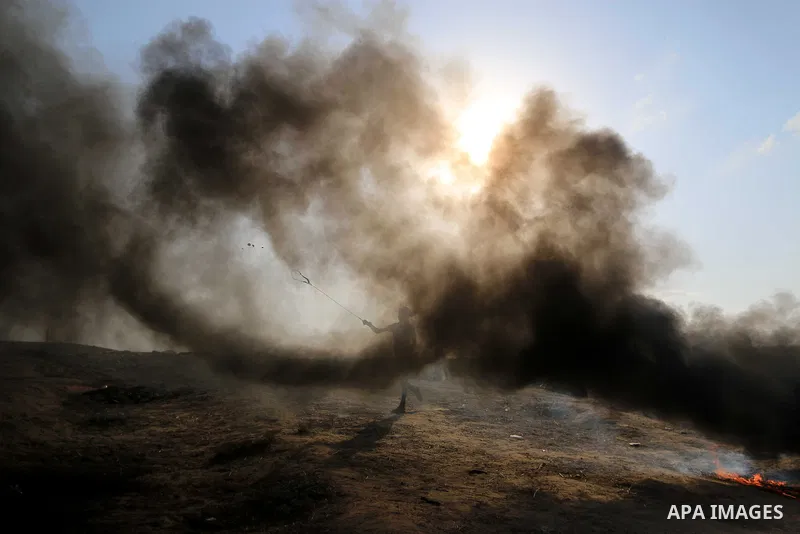 Palestinian protesters gather during clashes with Israeli troops in tents protest where Palestinians demand the right to return to their homeland at the Israel-Gaza border, in al-Bureij in the center of Gaza Strip on Aug...