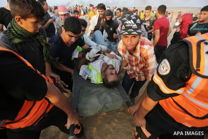 A wounded Palestinian paramedic is evacuated during clashes with Israeli troops in tents protest where Palestinians demand the right to return to their homeland at the Israel-Gaza border, in Khan Younis in the southern o...