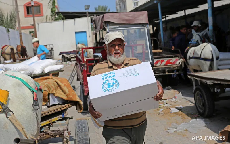 Palestinians receive food aid at an aid distribution center run by United Nations Relief and Works Agency (UNRWA) in Deir al-Balah in the center of Gaza Strip on September 1, 2018. The United States on Friday halted all...