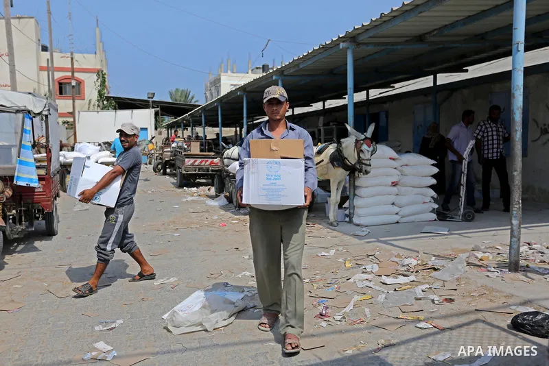 Palestinians receive food aid at an aid distribution center run by United Nations Relief and Works Agency (UNRWA) in Deir al-Balah in the center of Gaza Strip on September 1, 2018. The United States on Friday halted all...