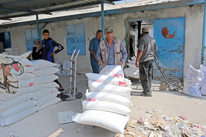 A Palestinian man pushes a cart loaded with sacks of flour at an aid distribution center run by United Nations Relief and Works Agency (UNRWA) in Deir al-Balah in the center of Gaza Strip on September 1, 2018. The United...