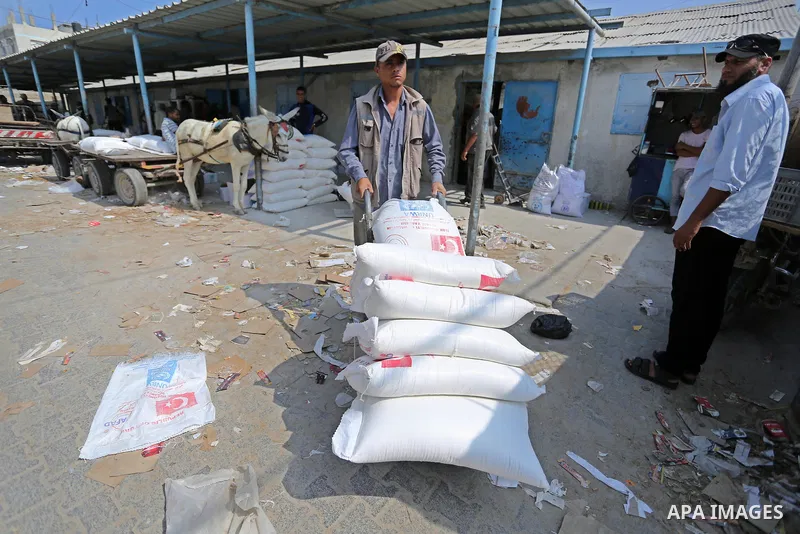 A Palestinian man pushes a cart loaded with sacks of flour at an aid distribution center run by United Nations Relief and Works Agency (UNRWA) in Deir al-Balah in the center of Gaza Strip on September 1, 2018. The United...