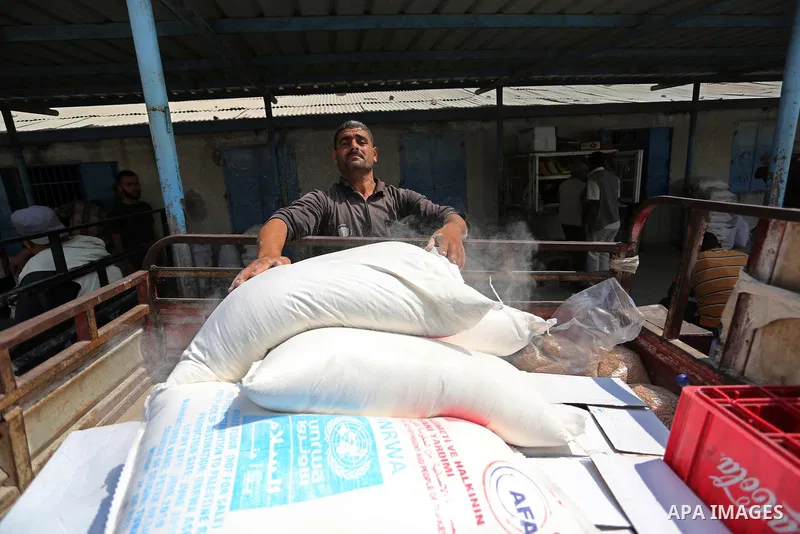 Palestinians receive food aid at an aid distribution center run by United Nations Relief and Works Agency (UNRWA) in Deir al-Balah in the center of Gaza Strip on September 1, 2018. The United States on Friday halted all...