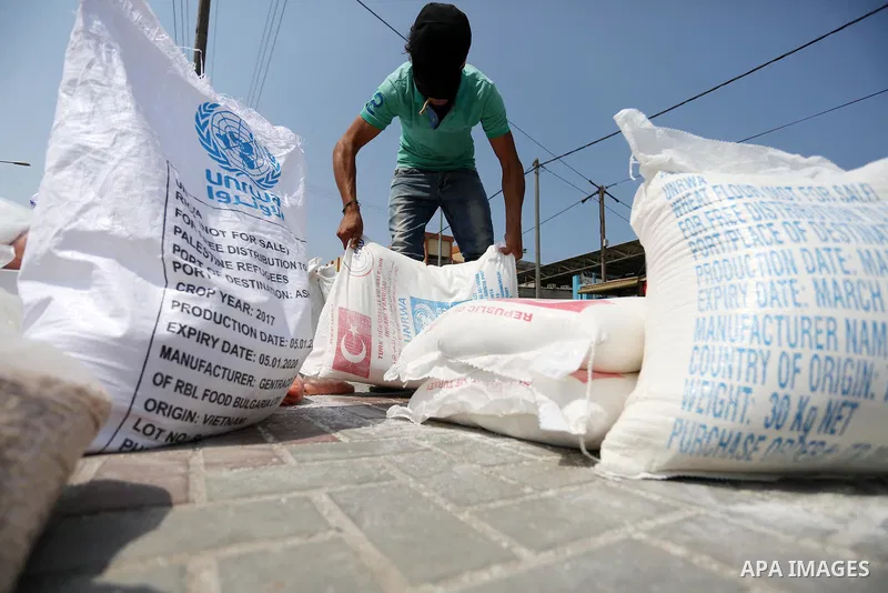 Palestinians receive food aid at an aid distribution center run by United Nations Relief and Works Agency (UNRWA) in Deir al-Balah in the center of Gaza Strip on September 1, 2018. The United States on Friday halted all...
