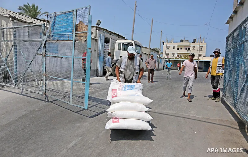 A Palestinian man pushes a cart loaded with sacks of flour at an aid distribution center run by United Nations Relief and Works Agency (UNRWA) in Deir al-Balah in the center of Gaza Strip on September 1, 2018. The United...