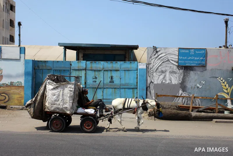 A Palestinian man rides a donkey cart past an aid distribution center run by United Nations Relief and Works Agency (UNRWA), at Al-Shati refugee camp, in Gaza City on September 1, 2018. The United States on Friday halted...