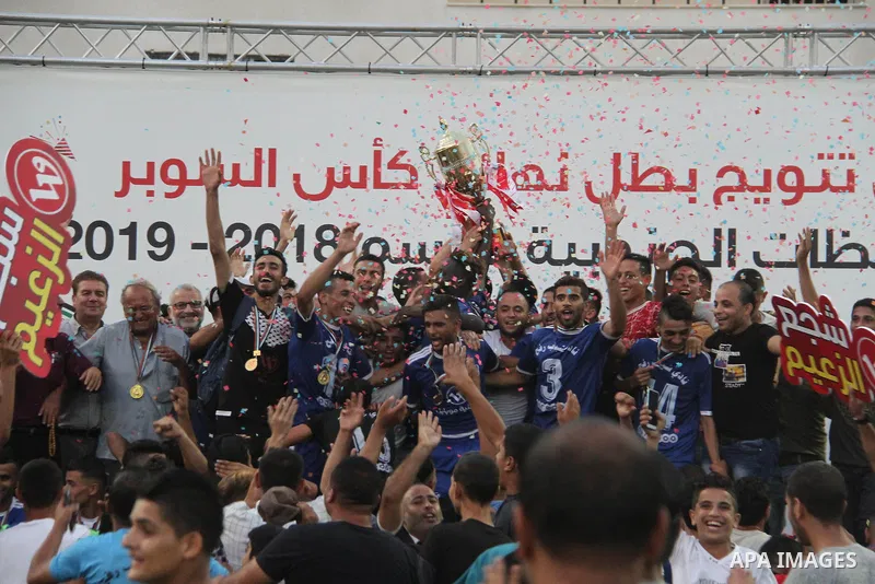 Palestinian Shabab Rafah players celebrate with the trophy after beating Shabab Khan Younis during Super Cup soccer match, at Palestine Stadium, in Gaza City on September 1, 2018. Photo by Mahmoud Ajour