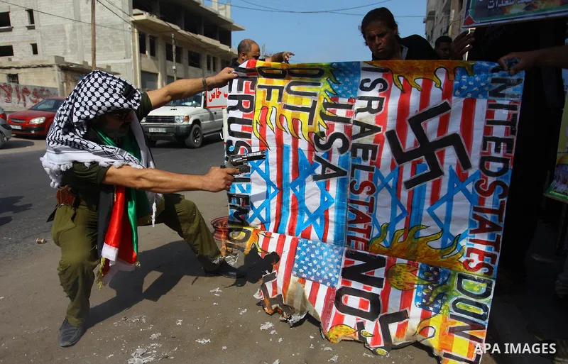 Palestinians burn an Israeli, British and U.S. flags during a protest to show solidarity with Palestinian prisoners held in Israeli jails, in front of Red cross office in Gaza city on Sept. 03, 2018. Photo by Mahmoud Ajo...