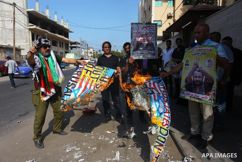 Palestinians burn an Israeli, British and U.S. flags during a protest to show solidarity with Palestinian prisoners held in Israeli jails, in front of Red cross office in Gaza city on Sept. 03, 2018. Photo by Mahmoud Ajo...