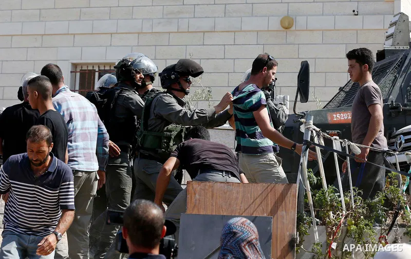Israeli border policemen stand guard as Israeli bulldozer demolishes four houses owned by Palestinian families which Israeli authorities said it was built without a permit, in the West Bank village of Walajeh, near Bethl...
