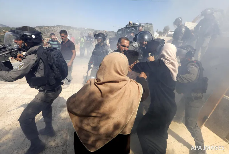 Israeli border policemen stand guard as Israeli bulldozer demolishes four houses owned by Palestinian families which Israeli authorities said it was built without a permit, in the West Bank village of Walajeh, near Bethl...