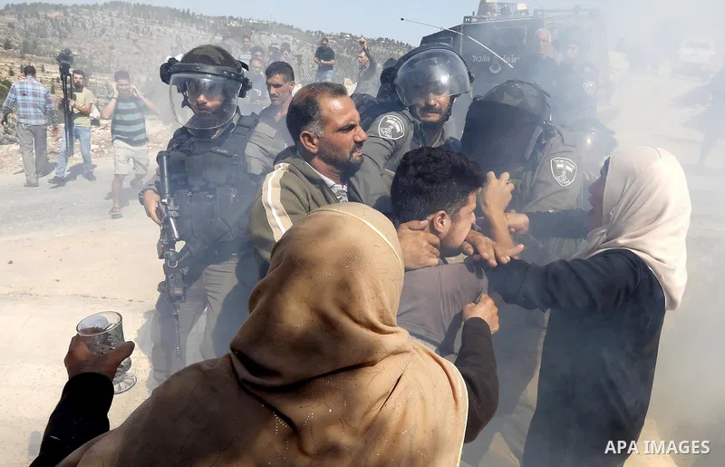 Israeli border policemen stand guard as Israeli bulldozer demolishes four houses owned by Palestinian families which Israeli authorities said it was built without a permit, in the West Bank village of Walajeh, near Bethl...