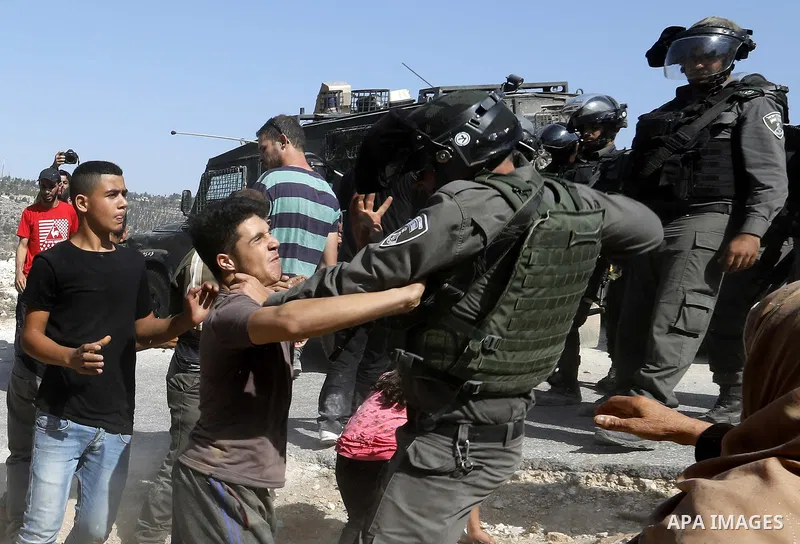 Israeli border policemen stand guard as Israeli bulldozer demolishes four houses owned by Palestinian families which Israeli authorities said it was built without a permit, in the West Bank village of Walajeh, near Bethl...