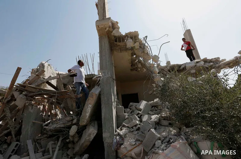 Palestinians inspect their house after Israeli bulldozer demolishes four houses owned by Palestinian families which Israeli authorities said it was built without a permit, in the West Bank village of Walajeh, near Bethle...