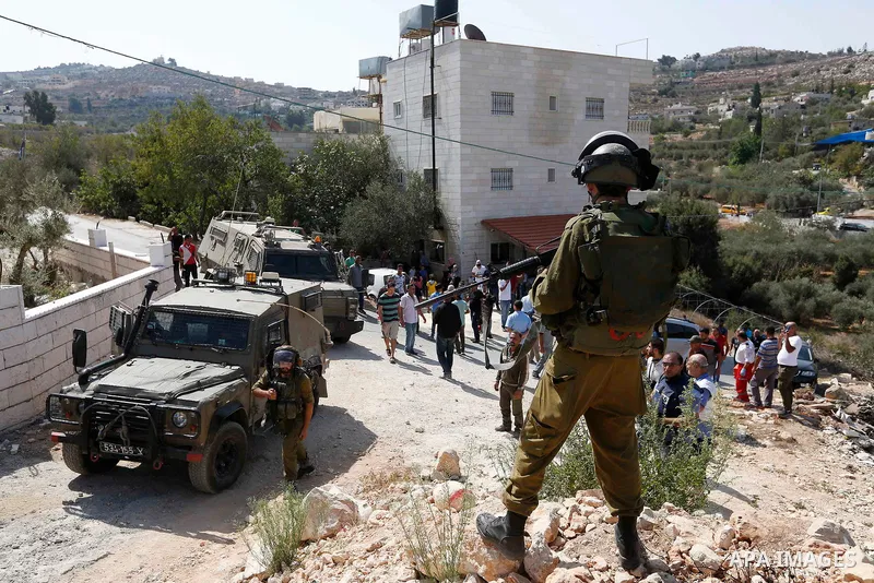 Israeli border policemen stand guard as Israeli bulldozer demolishes four houses owned by Palestinian families which Israeli authorities said it was built without a permit, in the West Bank village of Walajeh, near Bethl...