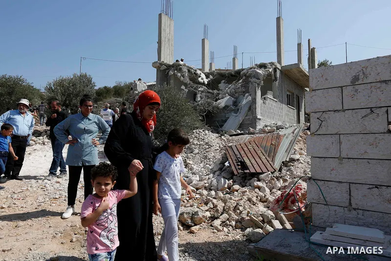Palestinians inspect their house after Israeli bulldozer demolishes four houses owned by Palestinian families which Israeli authorities said it was built without a permit, in the West Bank village of Walajeh, near Bethle...