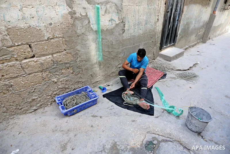 A Palestinian refugee man prepares a fishing net at Al-Shati refugee camp, in Gaza City on September 3, 2018. The United States halted all funding to United Nations' agency that helps Palestinian refugees. State Departme...