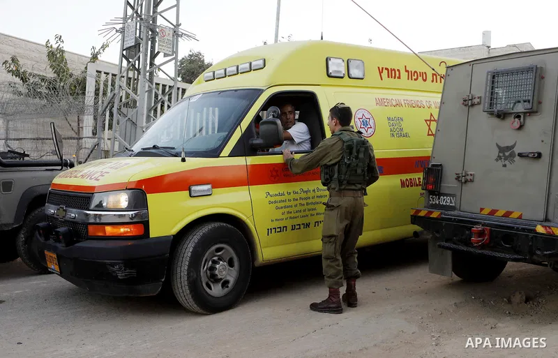 Israeli soldiers gather around an ambulance at the scene where a Palestinian, who according to the Israeli military attempted to stab a soldier, was shot dead, near a check point of the Israeli settlement of Kiryat Arba...
