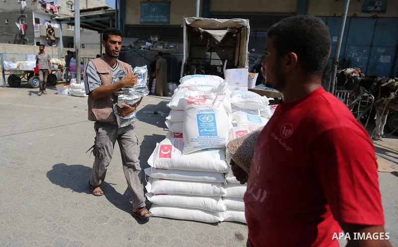 Palestinians receive food aid at an aid distribution center run by United Nations Relief and Works Agency (UNRWA) in Khan Younis in the southern Gaza Strip on September 4, 2018. The United States halted all funding to Un...