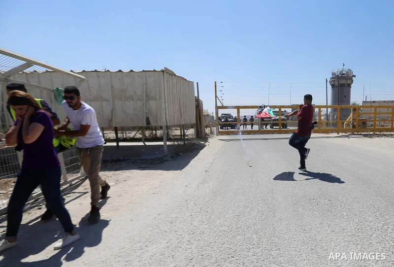 Palestinian journalists run for cover from a tear gas canister fired by Israeli troops during a protest demanding the release of Palestinian journalist Ali Dar Ali who was held in Israeli jails, outside Ofer military pri...