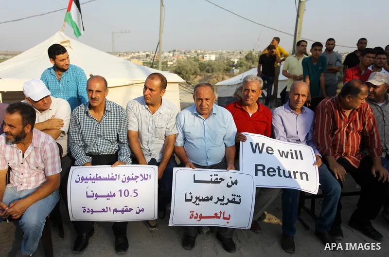 Palestinians take part during a protest against the United States decision to stop funding and backing the United Nations agency for Palestinian refugees (UNRWA) at the Erez crossing with Israel in the northern Gaza Stri...