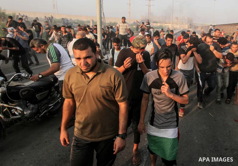 Palestinians gather during clashes with Israeli troops following a protest against the United States decision to stop funding and backing the United Nations agency for Palestinian refugees (UNRWA) at the Erez crossing wi...