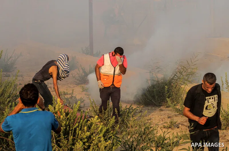 Palestinians gather during clashes with Israeli troops following a protest against the United States decision to stop funding and backing the United Nations agency for Palestinian refugees (UNRWA) at the Erez crossing wi...