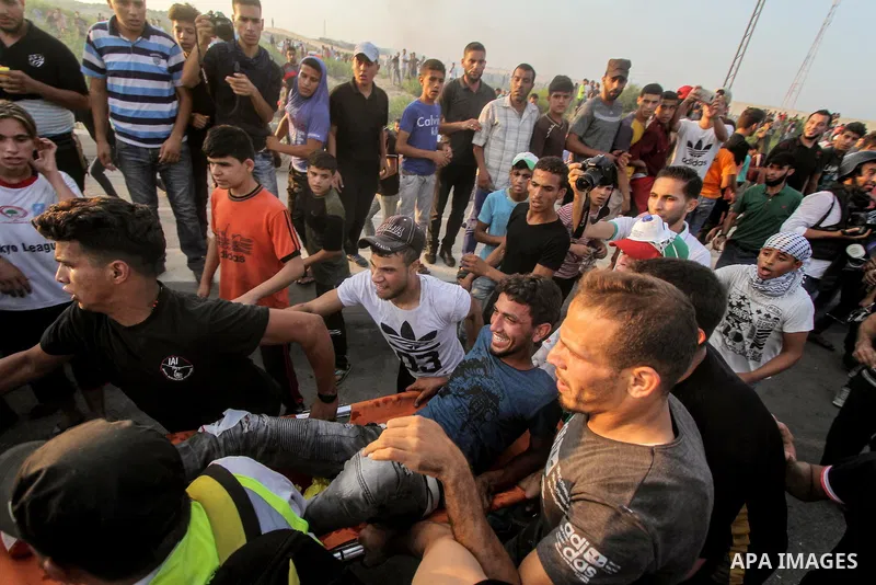 Palestinians gather during clashes with Israeli troops following a protest against the United States decision to stop funding and backing the United Nations agency for Palestinian refugees (UNRWA) at the Erez crossing wi...