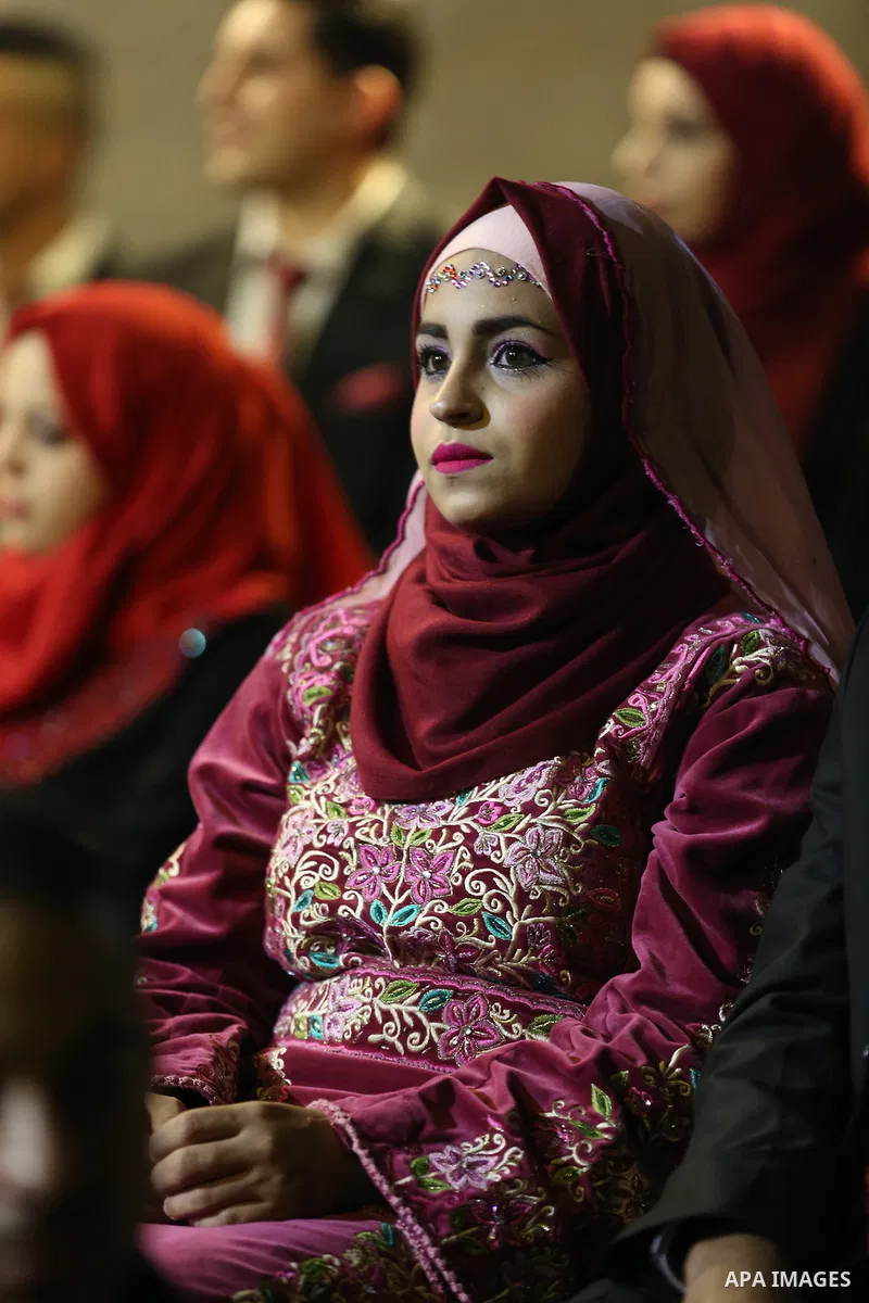 Palestinian 80 couples take part in a mass wedding ceremony in the West Bank city of Nablus on Sept 06, 2018. Photo by Shadi Jarar'ah