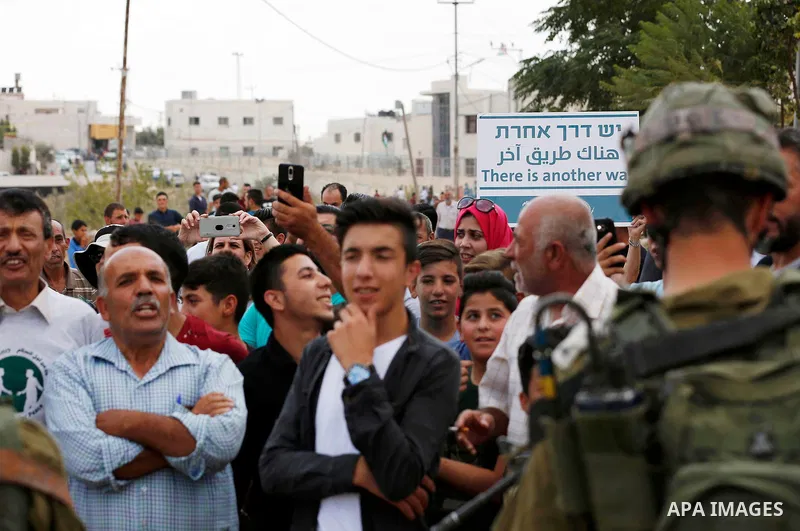 Palestinian protesters take part during a demonstration against the closure of a road since 18 years by the Israeli army in the West Bank village of Khirbat Qalqas, south of Hebron, on September 7, 2018. Photo by Wisam H...