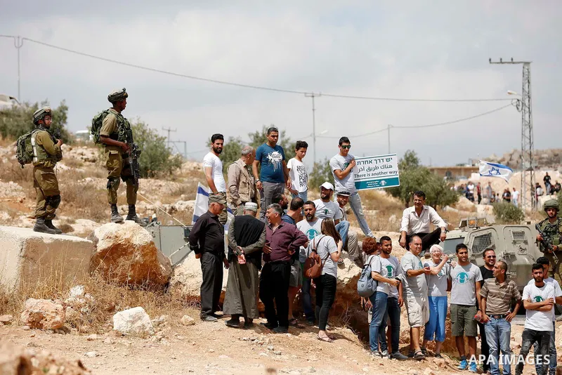 Palestinian protesters take part during a demonstration against the closure of a road since 18 years by the Israeli army in the West Bank village of Khirbat Qalqas, south of Hebron, on September 7, 2018. Photo by Wisam H...
