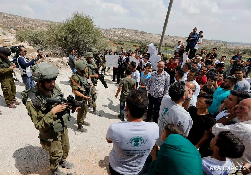 Palestinian protesters take part during a demonstration against the closure of a road since 18 years by the Israeli army in the West Bank village of Khirbat Qalqas, south of Hebron, on September 7, 2018. Photo by Wisam H...