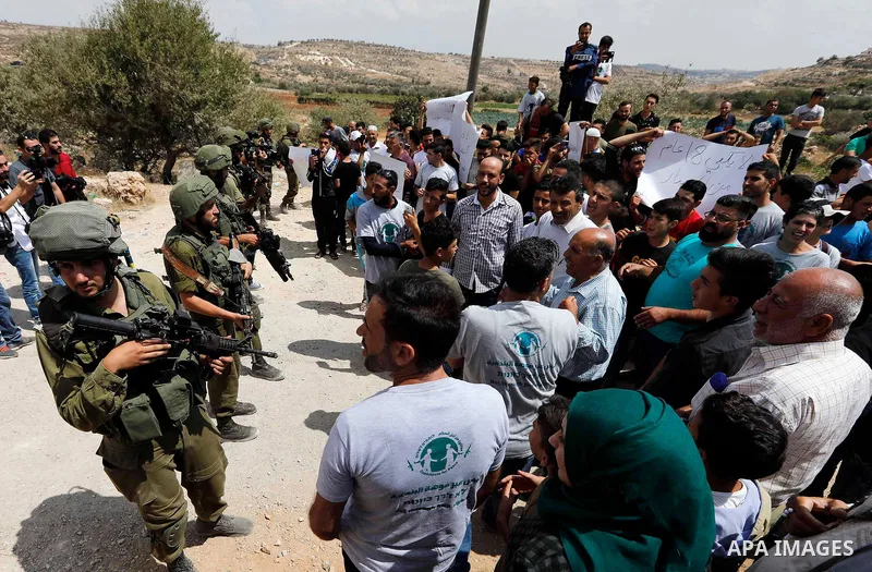Palestinian protesters take part during a demonstration against the closure of a road since 18 years by the Israeli army in the West Bank village of Khirbat Qalqas, south of Hebron, on September 7, 2018. Photo by Wisam H...