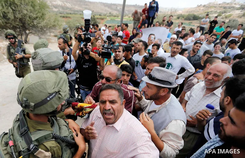 Palestinian protesters take part during a demonstration against the closure of a road since 18 years by the Israeli army in the West Bank village of Khirbat Qalqas, south of Hebron, on September 7, 2018. Photo by Wisam H...