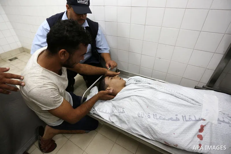 Relatives of Palestinian teenager Belal Khafaja, who was killed by Israeli forces during clashes in tents protest at the Israel-Gaza border, mourn over his body at a hospital in Rafah in the southern Gaza Strip on Septem...