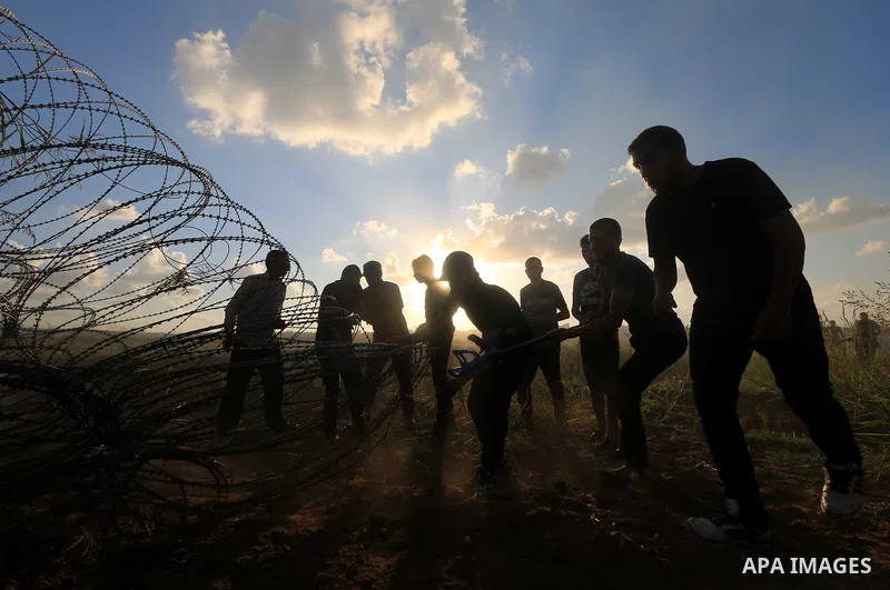 Palestinian protesters gather during clashes with Israeli troops in tents protest where Palestinians demand the right to return to their homeland at the Israel-Gaza border, in Al-Bureij in the center of Gaza Strip on Sep...