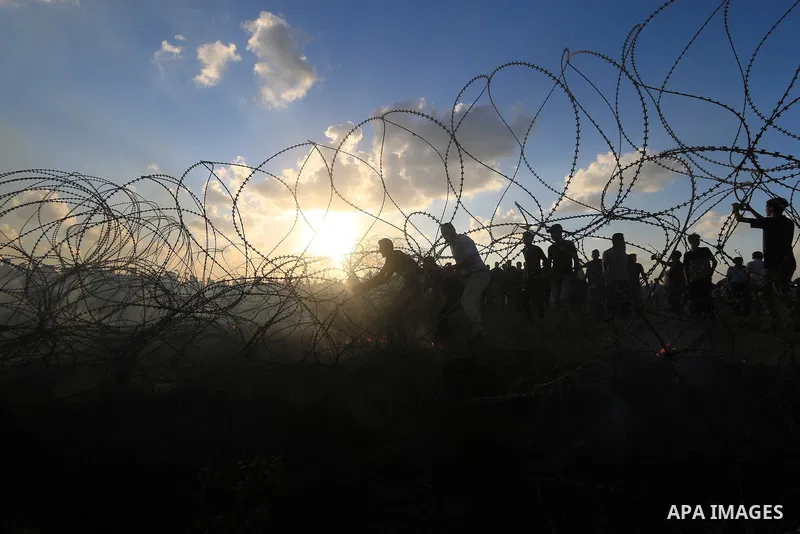 Palestinian protesters gather during clashes with Israeli troops in tents protest where Palestinians demand the right to return to their homeland at the Israel-Gaza border, in Al-Bureij in the center of Gaza Strip on Sep...