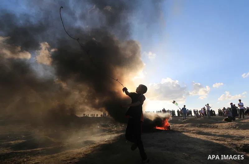 Palestinian protesters gather during clashes with Israeli troops in tents protest where Palestinians demand the right to return to their homeland at the Israel-Gaza border, in Al-Bureij in the center of Gaza Strip on Sep...