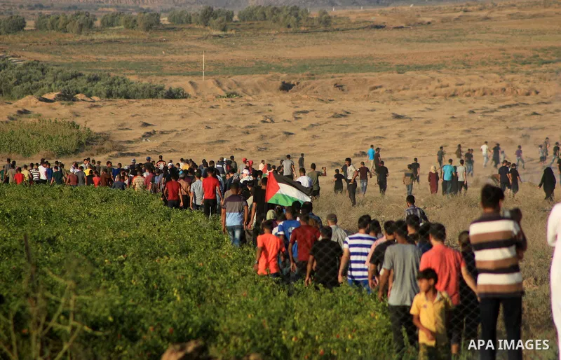 Palestinian protesters gather during clashes with Israeli troops in tents protest where Palestinians demand the right to return to their homeland at the Israel-Gaza border, in Al-Bureij in the center of Gaza Strip on Sep...