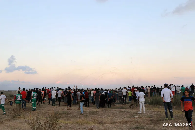 Palestinian protesters gather during clashes with Israeli troops in tents protest where Palestinians demand the right to return to their homeland at the Israel-Gaza border, in Al-Bureij in the center of Gaza Strip on Sep...