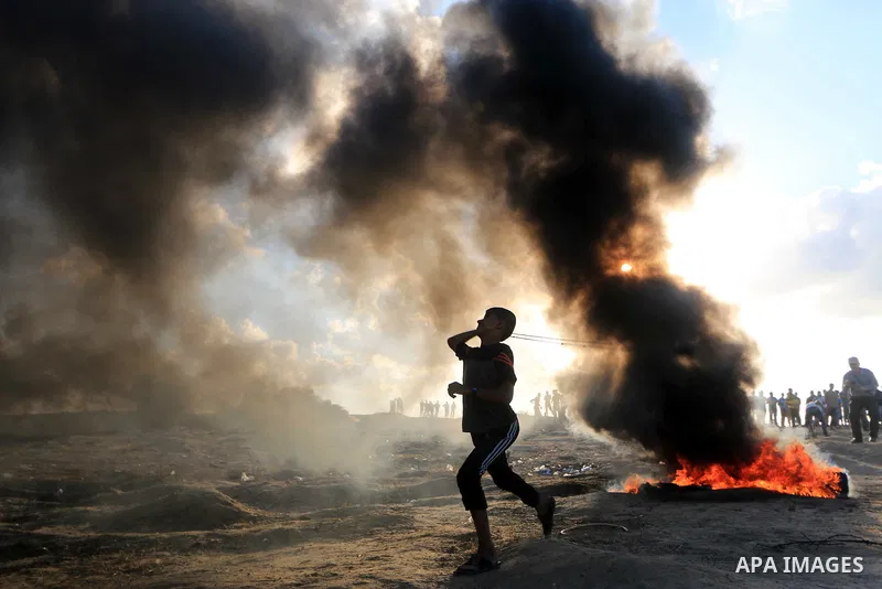 Palestinian protesters gather during clashes with Israeli troops in tents protest where Palestinians demand the right to return to their homeland at the Israel-Gaza border, in Al-Bureij in the center of Gaza Strip on Sep...