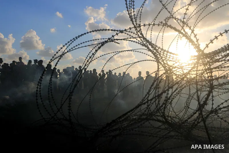 Palestinian protesters gather during clashes with Israeli troops in tents protest where Palestinians demand the right to return to their homeland at the Israel-Gaza border, in Al-Bureij in the center of Gaza Strip on Sep...