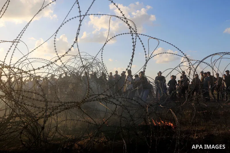 Palestinian protesters gather during clashes with Israeli troops in tents protest where Palestinians demand the right to return to their homeland at the Israel-Gaza border, in Al-Bureij in the center of Gaza Strip on Sep...