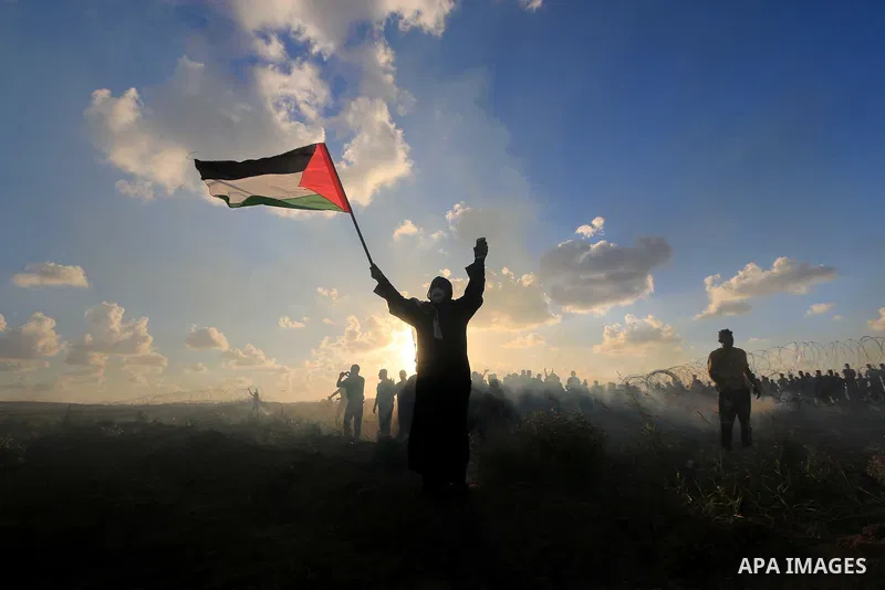 Palestinian protesters gather during clashes with Israeli troops in tents protest where Palestinians demand the right to return to their homeland at the Israel-Gaza border, in Al-Bureij in the center of Gaza Strip on Sep...