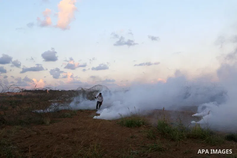 Palestinian protesters gather during clashes with Israeli troops in tents protest where Palestinians demand the right to return to their homeland at the Israel-Gaza border, in Al-Bureij in the center of Gaza Strip on Sep...