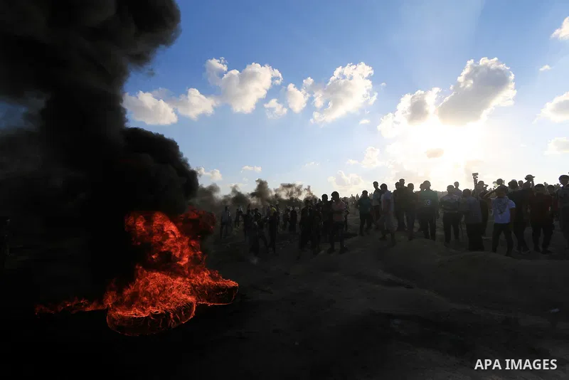 Palestinian protesters gather during clashes with Israeli troops in tents protest where Palestinians demand the right to return to their homeland at the Israel-Gaza border, in Al-Bureij in the center of Gaza Strip on Sep...